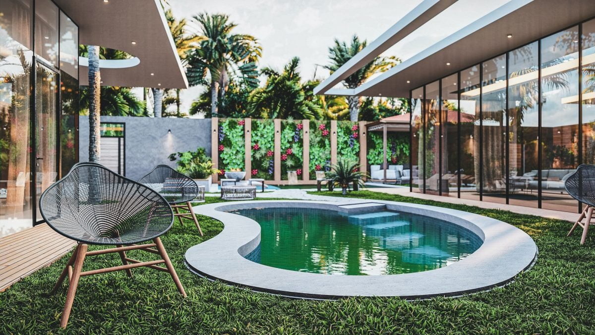 Modern backyard with a small kidney-shaped pool—one of the ideal pool shapes for small backyards—plus patio furniture, grass lawn, and vertical garden; surrounded by glass-walled buildings and palm trees.