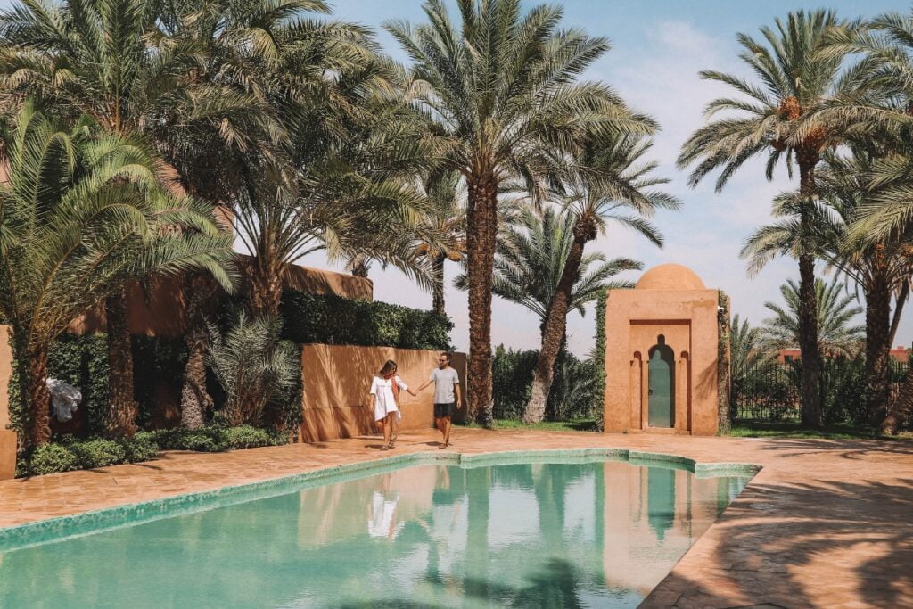 A pool cabana with palm trees in the background.