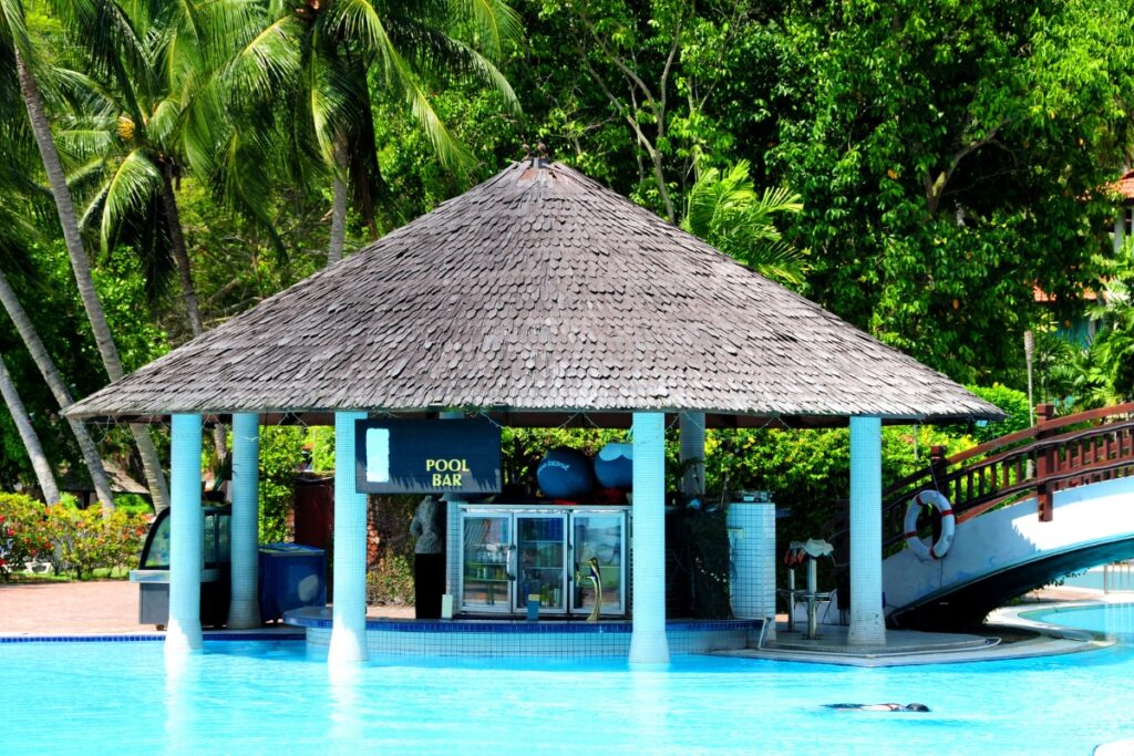 The pool is blue and surrounded by a cabana.