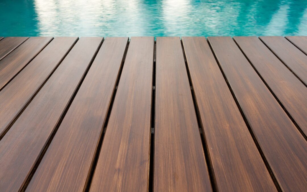 A wooden deck surrounding a swimming pool.