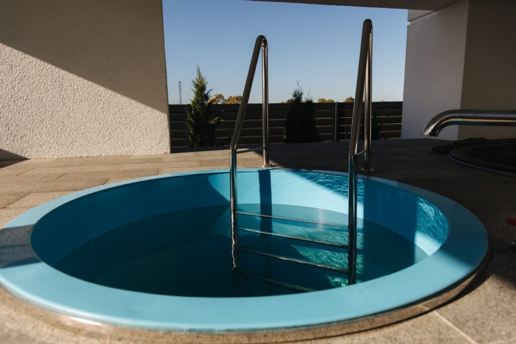An inground blue pool with a ladder.