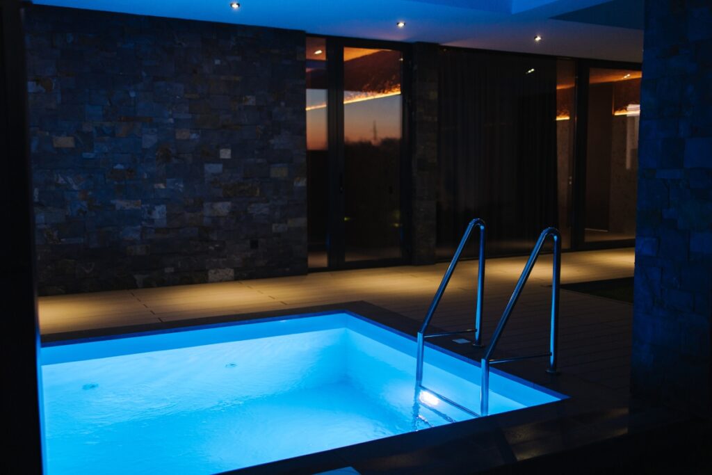 An inground plunge pool in a dark room.