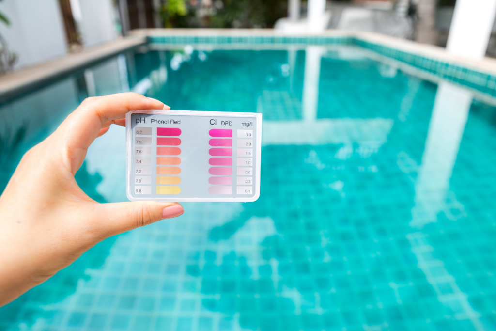 A hand showing the importance of balanced chemicals in a pool.