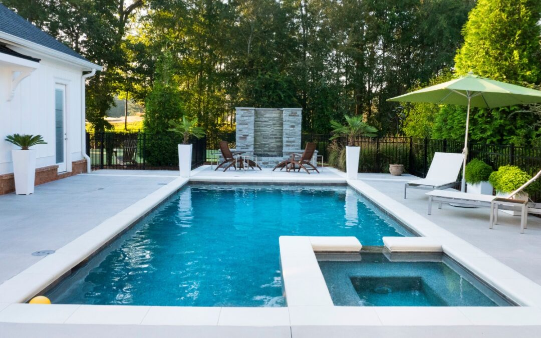 A swimming pool in a backyard with chairs, umbrellas, and energy-efficient features.