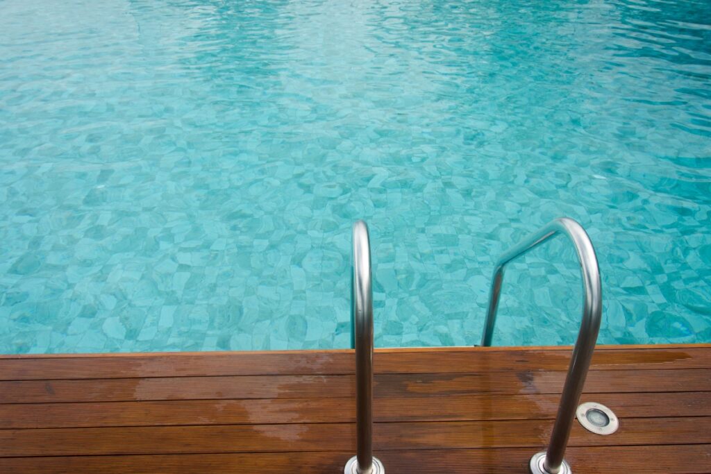 A wooden deck next to an energy-efficient swimming pool.