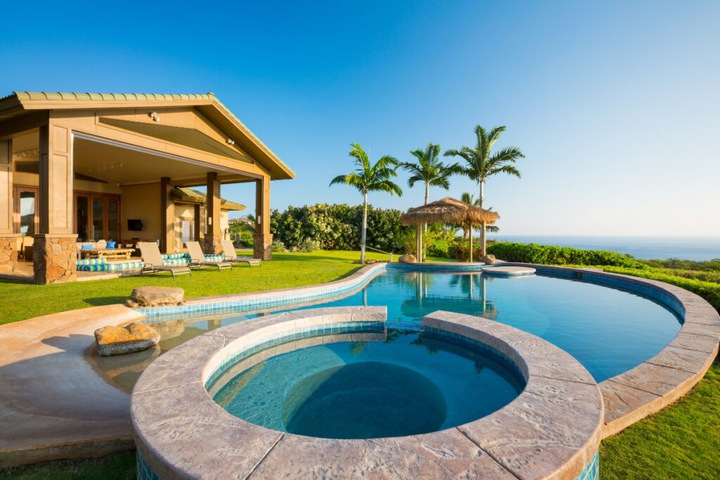 A house with an energy-efficient pool and a view of the ocean.