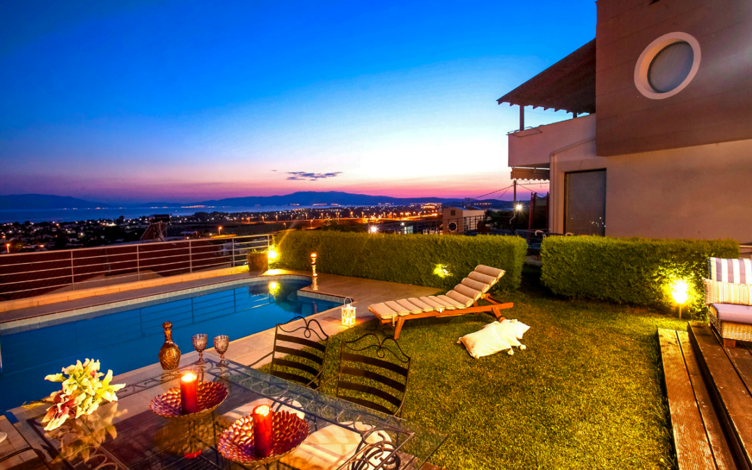 Rooftop terrace with loungers, pool, and decorative outdoor lighting at twilight.